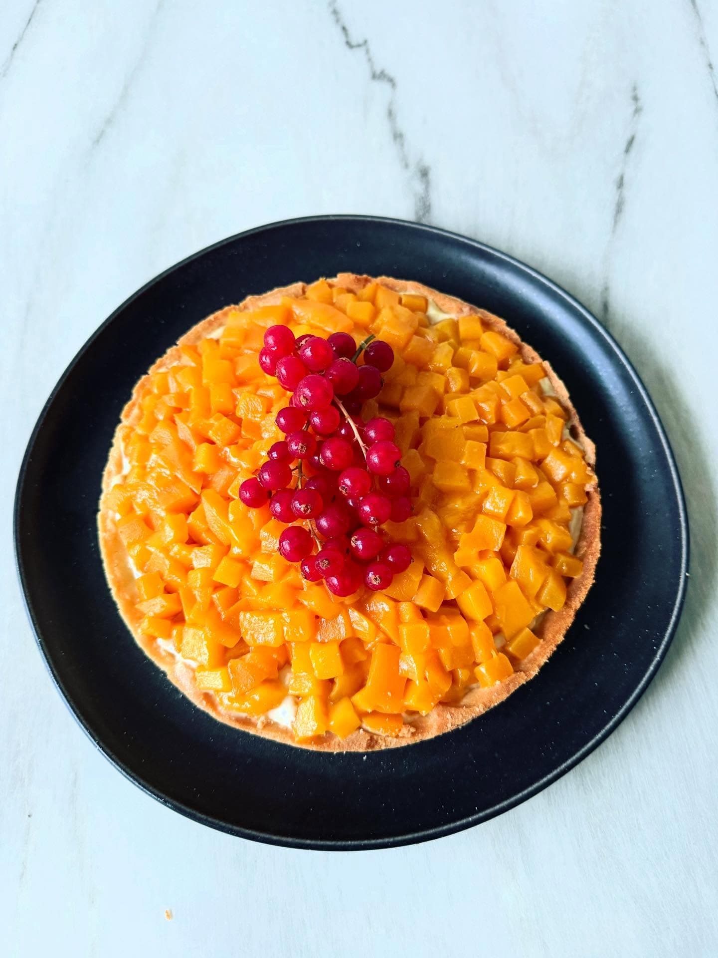 Mango and cardamom tart with cardamom crème pâtissière and red currants